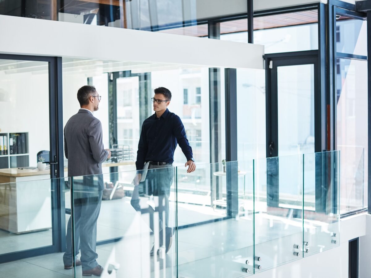 Business owner considering the view from a bright workshop doorway